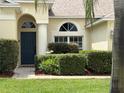 Inviting front entrance with manicured hedges, arched details, and a covered porch at 305 Grand Reserve Dr, Davenport, FL 33837