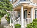 Cozy front porch with white railing and pillars, furnished with comfortable seating for relaxing outdoors at 411 Old Farm Ln, Winter Springs, FL 32708