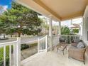 Relaxing front porch with comfortable chairs and a table, offering peaceful views of the street and nearby lake at 411 Old Farm Ln, Winter Springs, FL 32708