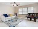 Inviting living room featuring tile floors, a ceiling fan, a comfortable sofa, and natural light from a large window at 425 Walnut St, Daytona Beach, FL 32114