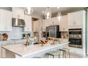 Bright modern kitchen featuring white cabinetry, stainless steel appliances, and a large island with seating at 4698 Coral Harbour Rd, Kissimmee, FL 34758