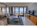 Cozy living room with comfortable seating, TV, and sliding glass doors leading to ocean view balcony at 5201 S Atlantic Ave # 301A, New Smyrna Beach, FL 32169