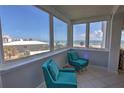 Bright sitting room featuring comfortable teal chairs and expansive ocean views through large windows at 5201 S Atlantic Ave # 301A, New Smyrna Beach, FL 32169