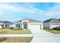 Charming single-story home with well manicured lawn, 2 car garage, and inviting curb appeal at 5342 Maddie Dr, Haines City, FL 33844