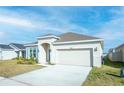 Attractive single-story home with an attached two-car garage, tidy lawn, and neutral color scheme at 5342 Maddie Dr, Haines City, FL 33844