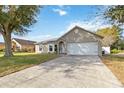 Inviting single-story home featuring an attached garage and a well-maintained front lawn at 542 Bent Oak Loop, Davenport, FL 33837