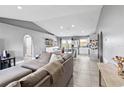 Bright and airy living room featuring a large comfy couch and direct access to the kitchen at 542 Bent Oak Loop, Davenport, FL 33837