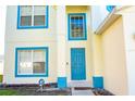Home's blue front door and porch, flanked by blue trim windows and an ADT security sign at 608 Bluebill Ct, Kissimmee, FL 34759