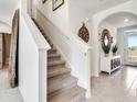 Bright entryway featuring tiled flooring, staircase with carpet, and elegant decor accents at 7089 Painted Bunting Way, St Cloud, FL 34773