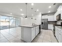 Open-concept kitchen with granite countertops, stainless steel appliances, and sliding doors leading to a pool at 7509 Oak Spring Ln, Davenport, FL 33837