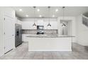 Bright kitchen featuring stainless steel appliances, granite countertops, and a large island with pendant lighting at 7509 Oak Spring Ln, Davenport, FL 33837