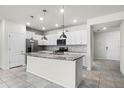 Modern kitchen featuring white cabinetry, granite countertops, a center island and stainless steel appliances at 7509 Oak Spring Ln, Davenport, FL 33837