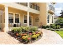 Inviting two-story home featuring a landscaped yard, covered porch with decorative columns and a brick walkway at 8424 Lake Burden Cir, Windermere, FL 34786