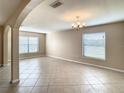 Open living room featuring tile flooring, neutral paint, an archway, and a decorative chandelier at 1515 Angler Ave, Kissimmee, FL 34746
