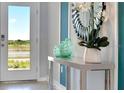 Inviting entryway with stylish mirror, decorative vases, and a view to the outdoor landscape at 1712 Three Bars Rd, Kissimmee, FL 34744