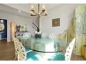 Elegant dining room with a unique glass table, designer chairs and modern chandelier at 1832 Farnham Dr, Ocoee, FL 34761