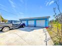 Three-car garage offers ample parking space, along with a blue exterior that matches the main house at 200 Dr Martin Luther King Jr Se St, Fort Meade, FL 33841