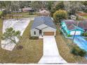 Aerial view of a one story home with a gray roof, long driveway, and a landscaped yard at 281 Luis Ln, Debary, FL 32713