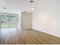 Bright, open living room with wood-look flooring and sliding glass doors to the backyard at 281 Luis Ln, Debary, FL 32713