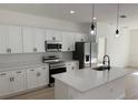 Modern kitchen featuring white cabinets, stainless steel appliances, and quartz countertops at 2942 Sw 162Nd St, Ocala, FL 34473