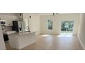 Bright and airy living room with modern light fixtures, open floor plan, and sliding glass doors to the backyard at 2942 Sw 162Nd St, Ocala, FL 34473