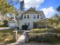 Inviting two-story home with lush landscaping, front gate and a detached garage at 340 W 9Th Ave, Mount Dora, FL 32757