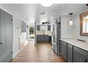 Kitchen featuring grey cabinets, stainless steel appliances, and wood floors at 402 E Orlando Ave # 18C, Ocoee, FL 34761