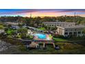 Scenic aerial view of the property with a pool, dock, and waterfront access at sunset at 402 E Orlando Ave # 18C, Ocoee, FL 34761