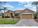 Attractive single-story home features a red tile roof, two-car garage, and well-maintained landscaping at 4036 Bougainvillea Pl, Kissimmee, FL 34746