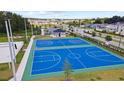Full aerial shot of community basketball court with colorful playground in the background and nearby residences at 4110 Gooseberry Trl, Kissimmee, FL 34746