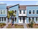 Charming blue two-story townhome featuring modern design, balcony and well-maintained landscaping at 6403 Cyrils Dr, St Cloud, FL 34771