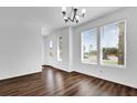 Bright and airy living room with hardwood floors, large windows, and a modern chandelier at 6403 Cyrils Dr, St Cloud, FL 34771