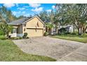 Long brick driveway leading to a well-maintained home with mature trees in a sunny neighborhood at 873 Gulf Land Dr, Apopka, FL 32712