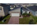 Single Gathering home featuring a paved driveway, attached garage, and well-maintained front lawn in a residential area at 1114 Turquoise Waves Cv, Kissimmee, FL 34747
