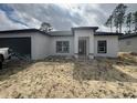 Modern single-story home with a two-car garage, minimal landscaping, and a contemporary front entrance at 13449 Sw 60Th Avenue Rd, Ocala, FL 34473