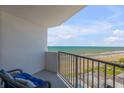 Balcony view featuring an oceanfront view with chair and railing at 1415 Ocean Shore Blvd # 704, Ormond Beach, FL 32176