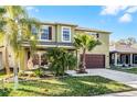 Charming two-story home with lush landscaping, beautiful palms, and a two car garage at 2564 Bullion Loop, Sanford, FL 32771