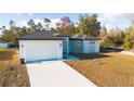 Attractive single-story home with a two-car garage, light-colored exterior, and a well-maintained lawn at 2629 Sw 163Rd Pl, Ocala, FL 34473