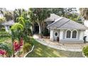 Attractive front exterior featuring a meticulously landscaped lawn, elegant columns, and a tiled roof at 4178 S Chickasaw Trl, Orlando, FL 32829