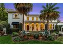 Elegant home with a covered entryway, arched windows, and beautiful nighttime illumination at 419 Raehn St, Orlando, FL 32806