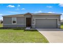 Attractive single-story home features a well-manicured lawn and a two-car garage with a concrete driveway at 429 Ohio Way, Kissimmee, FL 34759