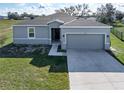 Attractive single-story home with a well-manicured lawn and a two-car garage with a concrete driveway at 429 Ohio Way, Kissimmee, FL 34759