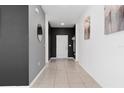 Hallway with neutral tile flooring, decorative mirrors and artwork, and dark grey accent walls at 429 Ohio Way, Kissimmee, FL 34759