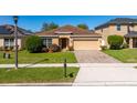 Attractive one-story home boasts a well-kept lawn, tan exterior and a two-car garage at 4605 Kalispell Rd, Kissimmee, FL 34758