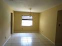 A brightly lit dining room features neutral walls, tile flooring, chandelier, and a window with blinds at 4790 Point Look Out Rd, Orlando, FL 32808