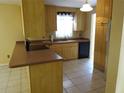 An eat-in kitchen with wood cabinets, neutral countertops, a tile backsplash, and stainless steel appliances at 4790 Point Look Out Rd, Orlando, FL 32808