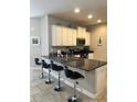 Well-equipped kitchen featuring granite countertops, bar seating, and stainless steel appliances at 5356 Oakbourne Ave, Davenport, FL 33837