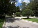 Paver driveway leads to a landscaped entrance with manicured shrubbery and decorative street lamps at 586 Brantley Terrace Way # 201, Altamonte Springs, FL 32714