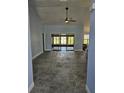 Spacious living room with tile floors, ceiling fan, and sliding glass doors leading to the outdoors at 703 Pine Shores Cir, New Smyrna Beach, FL 32168