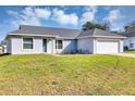 Charming single-story home with a well-manicured lawn, neutral exterior paint, and a two-car garage at 7139 Se 122Nd Ln, Belleview, FL 34420
